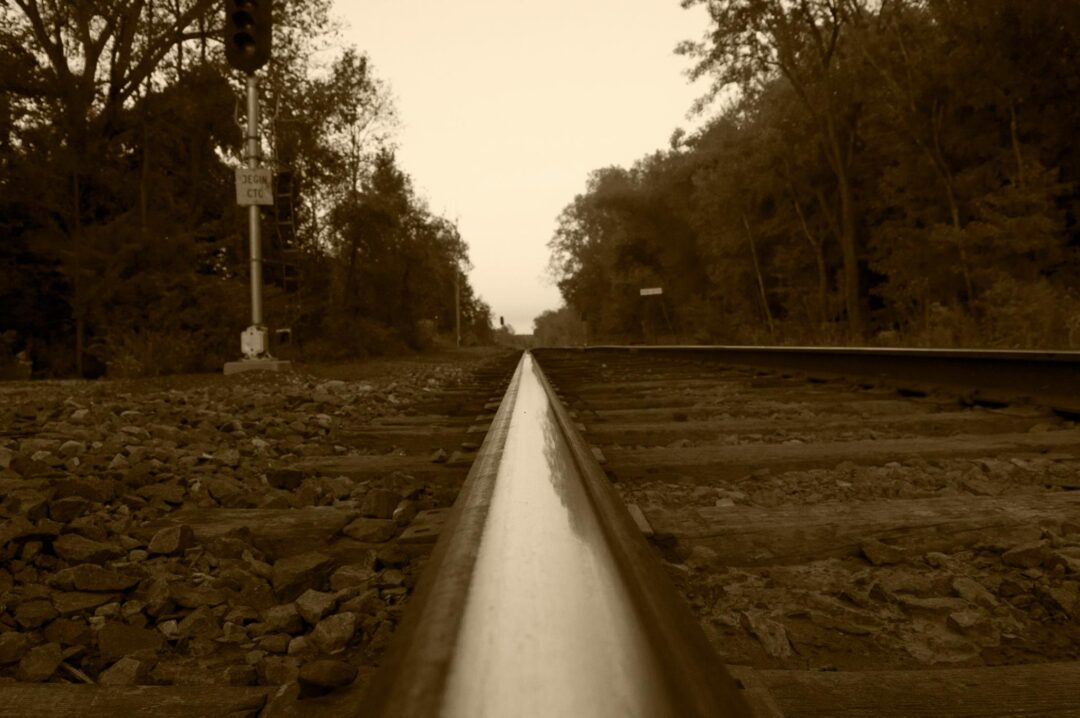 a sepia image down a rail line